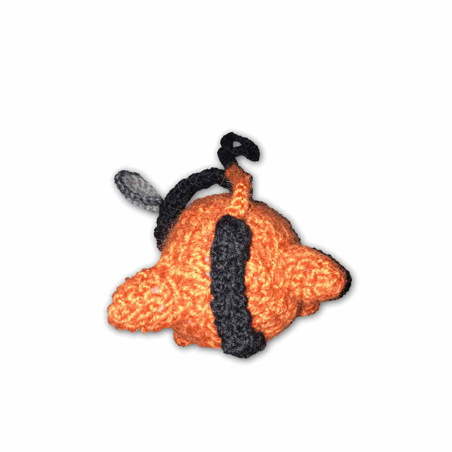 gif of a crocheted Pochita-plushie. he is an orange dog from hit series chainsaw man and he is spinning